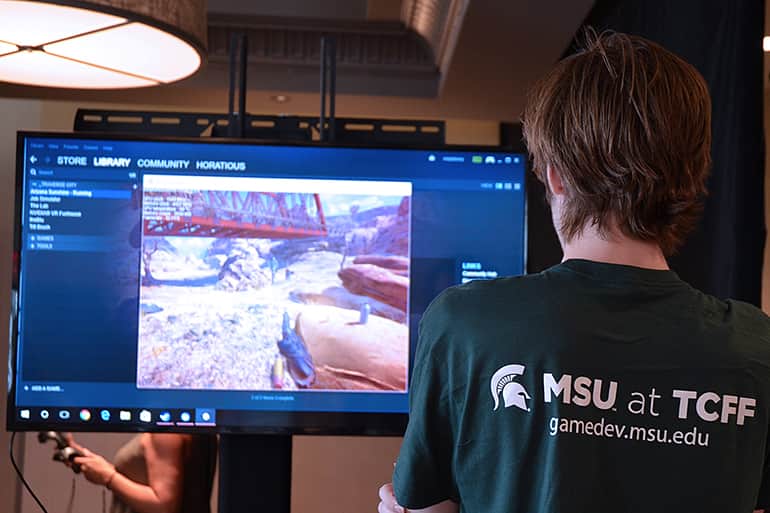 Game design student playing a MSU designed game at the Traverse City Film Festival.