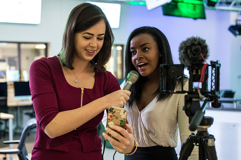 Two female journalism students prepare for on camera assignment.