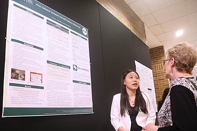 Advertising graduate student discusses her research with professor.