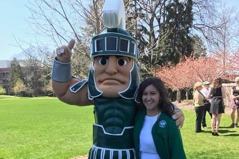 Haley Kluge standing next to Sparty.