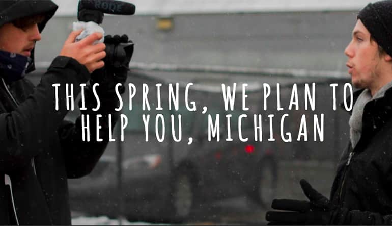 Photographer taking a photo of a 20 something male. Text on the photo says, "This spring, we plan to help you, Michigan."