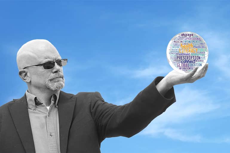 Professor RV Rikard holding a globe in his hand.