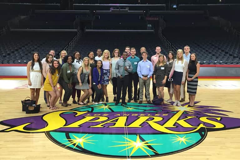Students in the Los Angeles Study Away class standing together for a group shot in center court of the LA Sparks basketball arena.