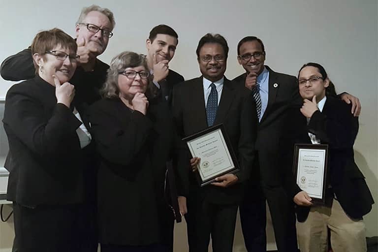 Group shot of ComArtSci faculty and staff posing with Prabu and their awards. From left to right: Ann Hoffman, Karl Gude, Mary Bresnahan, Juan Mundel, Swarnavel Pallai, Prabu David, and Robby Ratan.