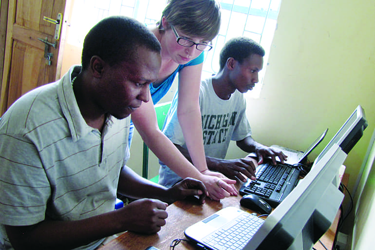 Media and Information student updating an old computer in an Tanzania school