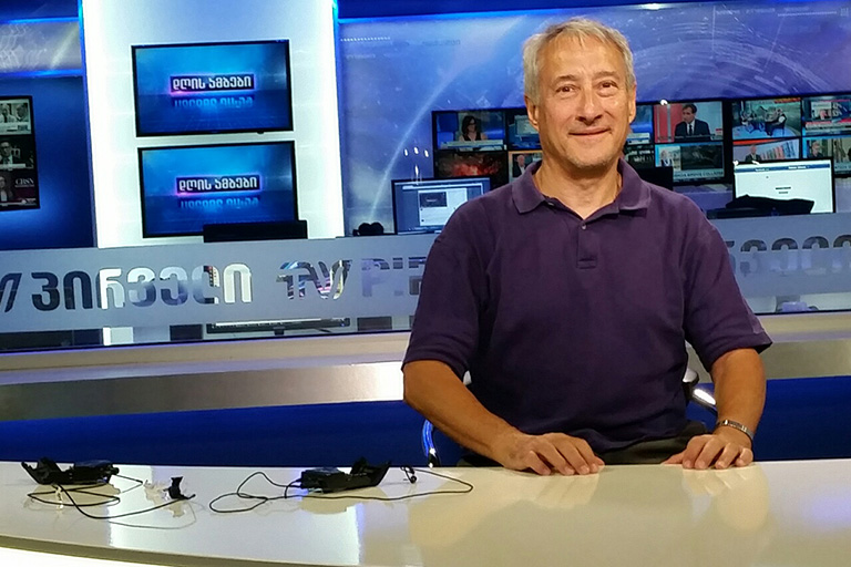 School of Journalism Professor Eric Freedman sits at the news desk of TV Pirveli, an independent channel where the dean of the School of Media at Caucasus University hosts two weekly shows. Freedman is a visiting professor at the school, located in the Republic of Georgia, for the 2018 fall semester.