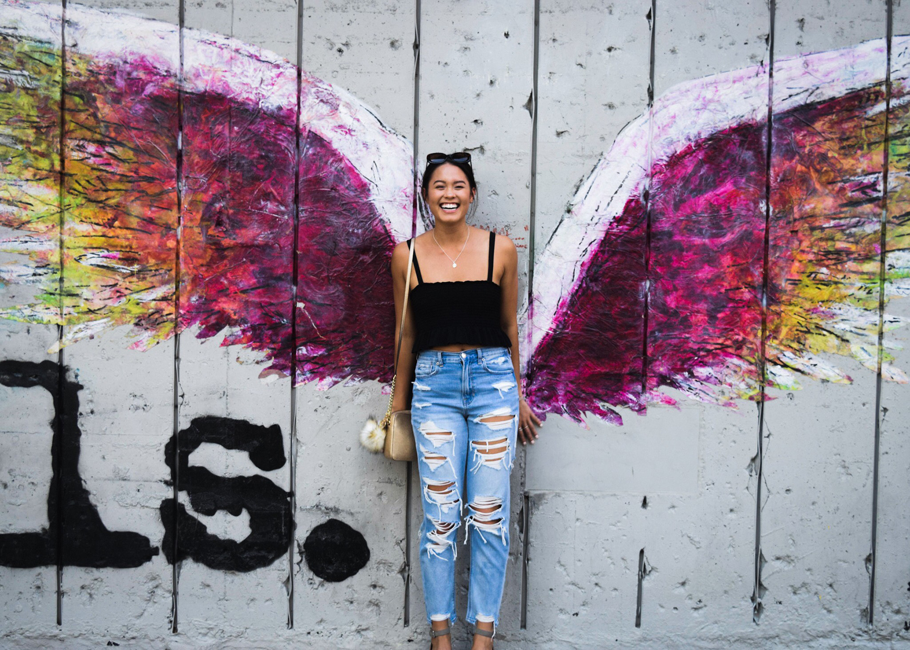 Photo of student posing in front of street art in LA