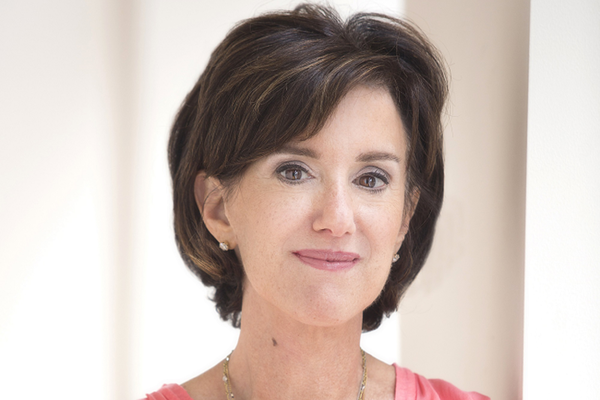 Susan Packard, former HGTV CEO, smiling against tan backdrop