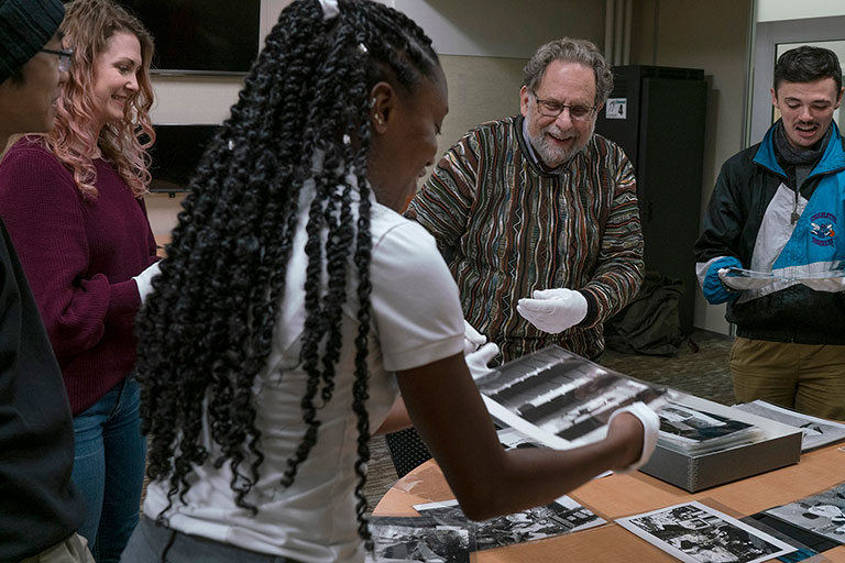Students looking at photographs of post-Apartheid South Africa made by the late Leonard Freed, an important 20th century photojournalist. The photographs are housed in MSU Special Collections.