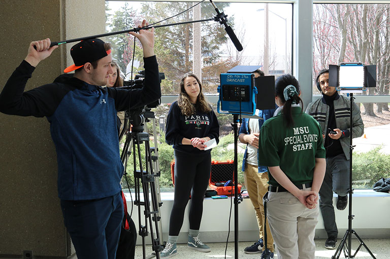 Behind the scenes view of students shooting a film 