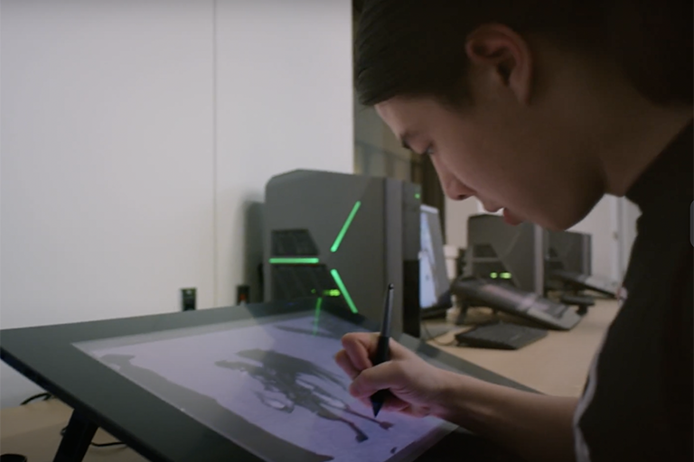 Peter Burroughs drawing a design for a game being developed 