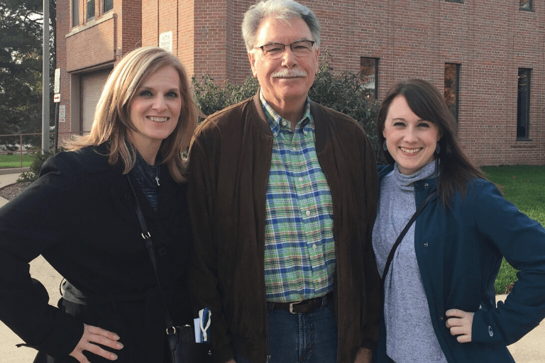 Teresa is standing, left, next to Peter LaPine, middle, and fellow alumna Anna Blakely, right