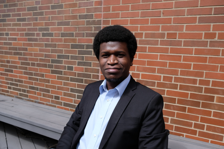 Photo of Rellika Kisyula with a brick wall in the background