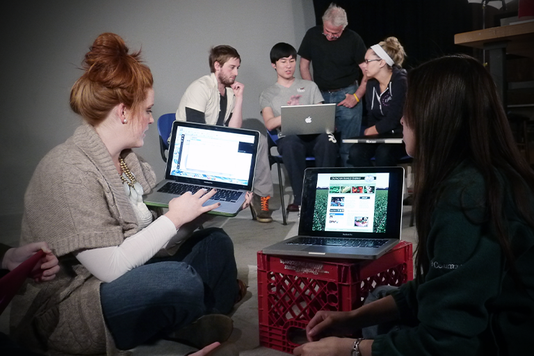 Student showing work on a computer to another student