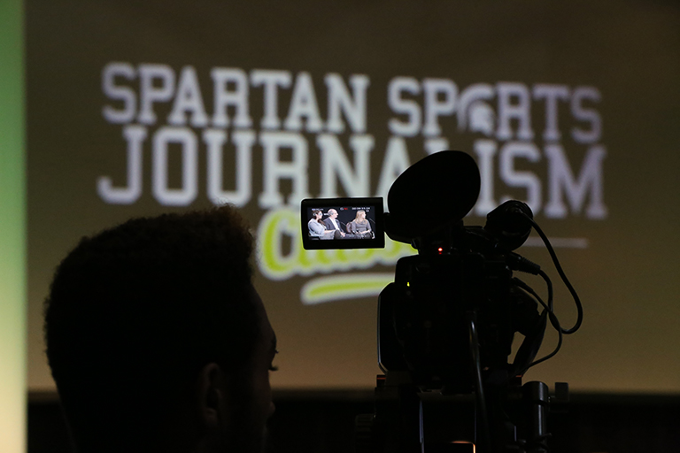 Silhouette of someone recording with a broadcast camera