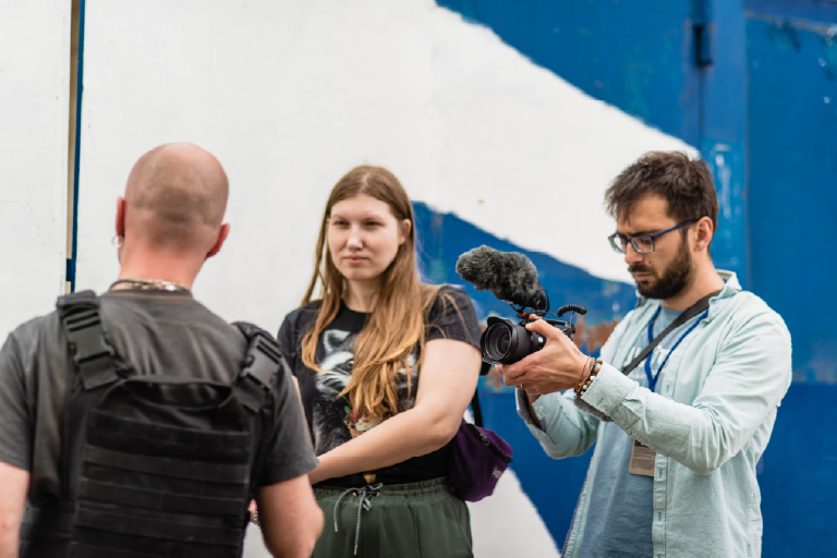 Photojournalists photographing a man