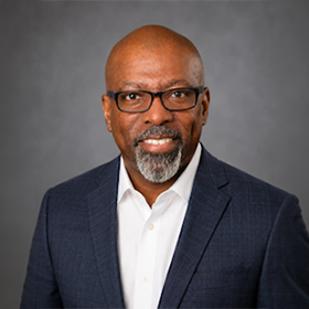 Photo of Shawn Turner in a suit and wearing glasses