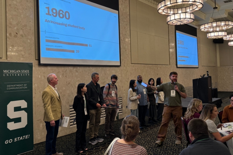 Presenters standing at front of stage of Communication Science Futures