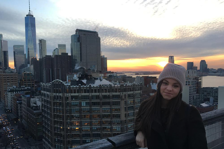 Advertising senior Brooke Segal poses for a picture on a rooftop in NYC with the city behind her.