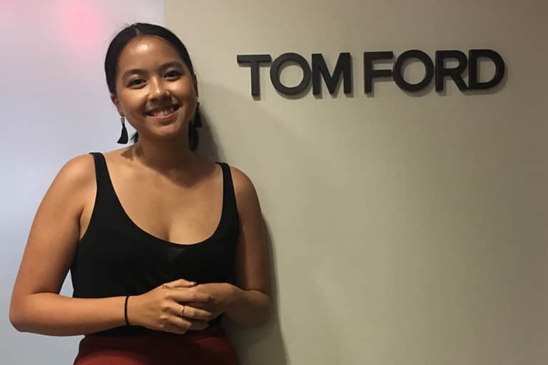 Advertising student Julia Le poses beside Tom Ford sign.