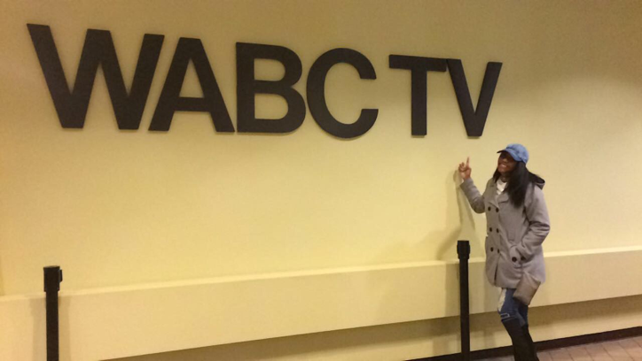 Ashley Reed standing next to the WABC TV call letters.
