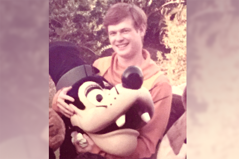 a young Craig Murray holds a costume head for the Disney character "Goofy"