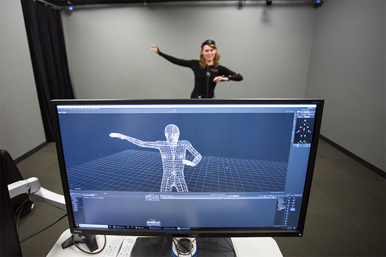 a research participant wears a motion capture suit while a computer program creates and displays an animation from the body movement