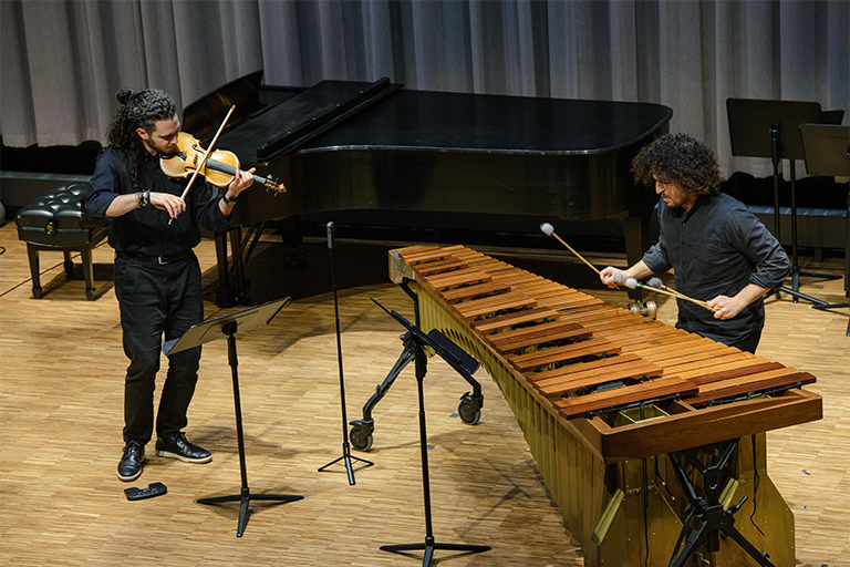 Matheus Souza and Marco Shirripa play the violin and marimba on stage.