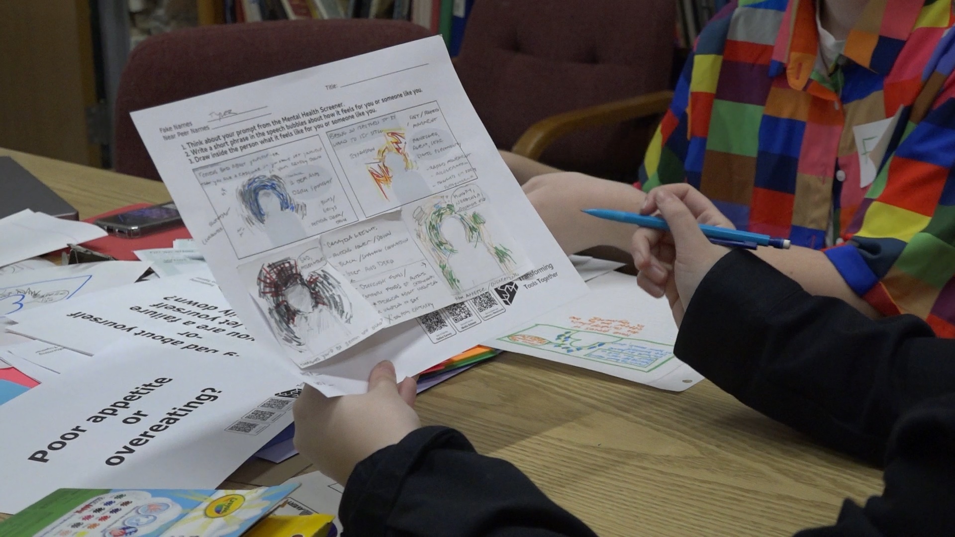 Student holding handout of an exercise talking about feelings.
