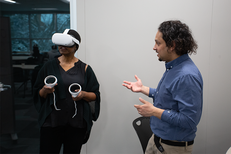 Teresa Mastin and Robby Ratan interacting during a VR workshop.