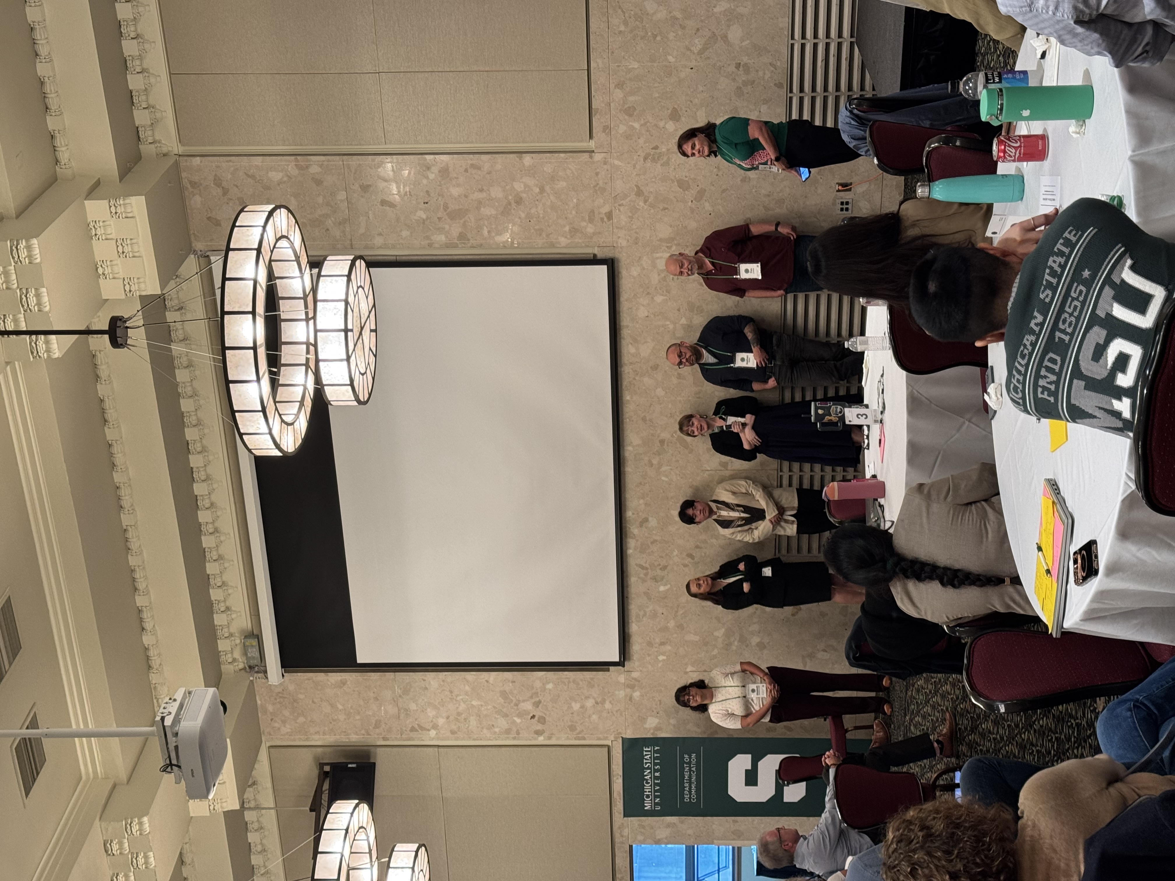 Presenters standing at front of stage of Communication Science Futures
